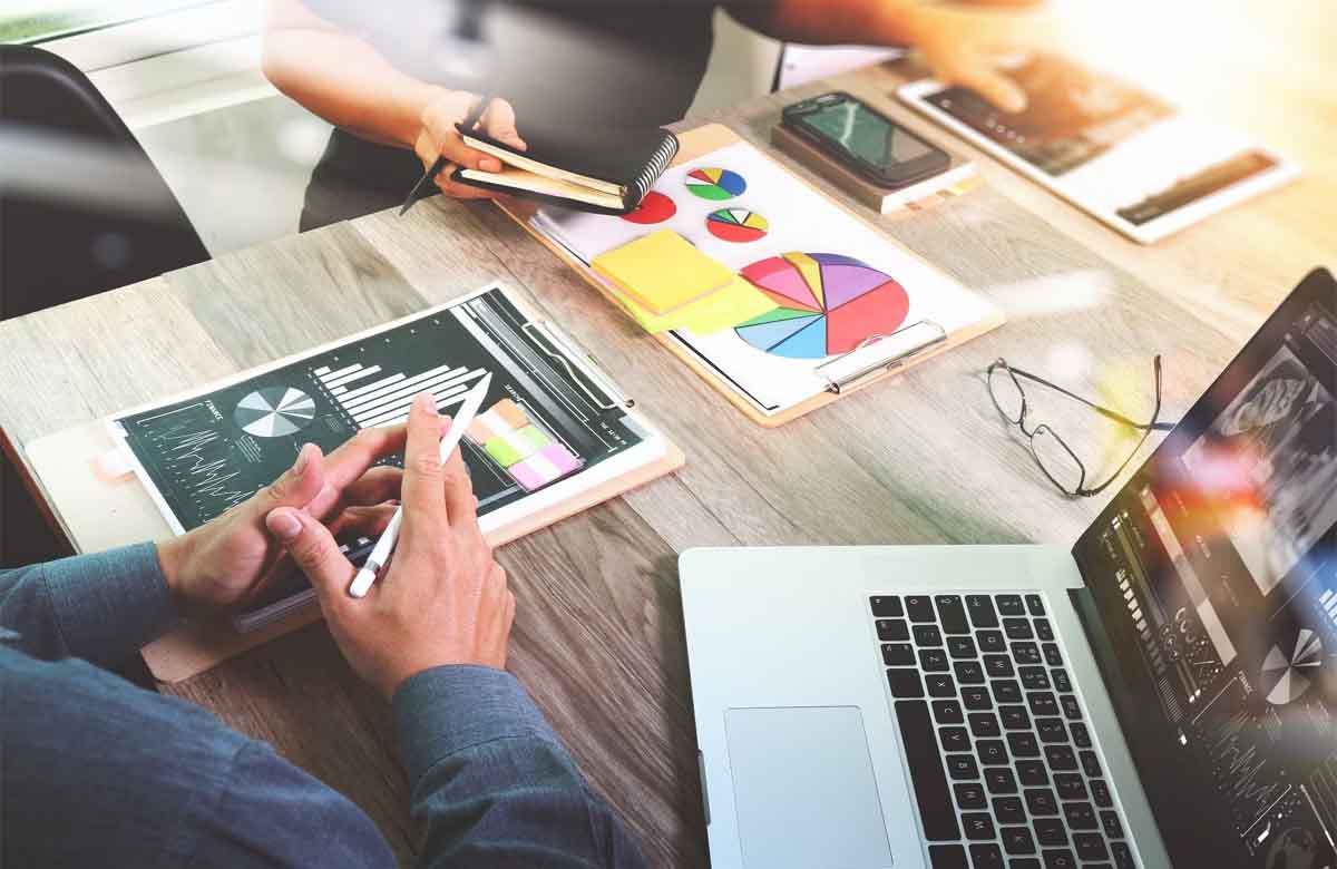Digital Marketing Consultant reviewing analytics and charts with a team during a strategy meeting.